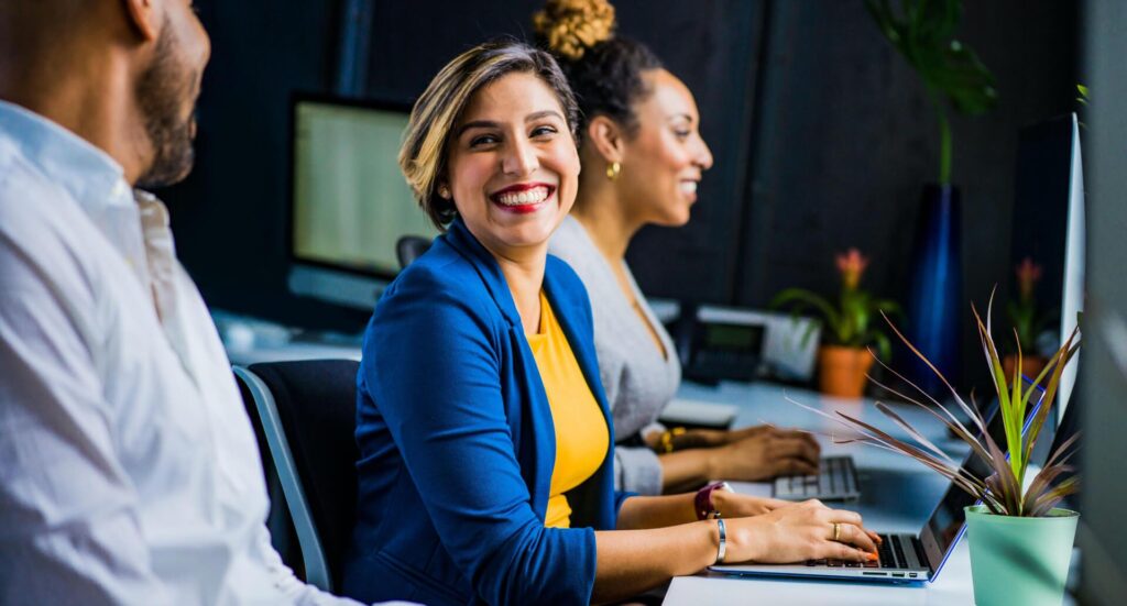 A smiling lady entrepreneur in a blue coat and a yellow tshirt