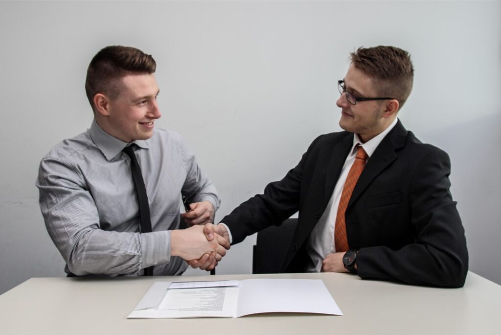 two men shaking hands offering perk to employee